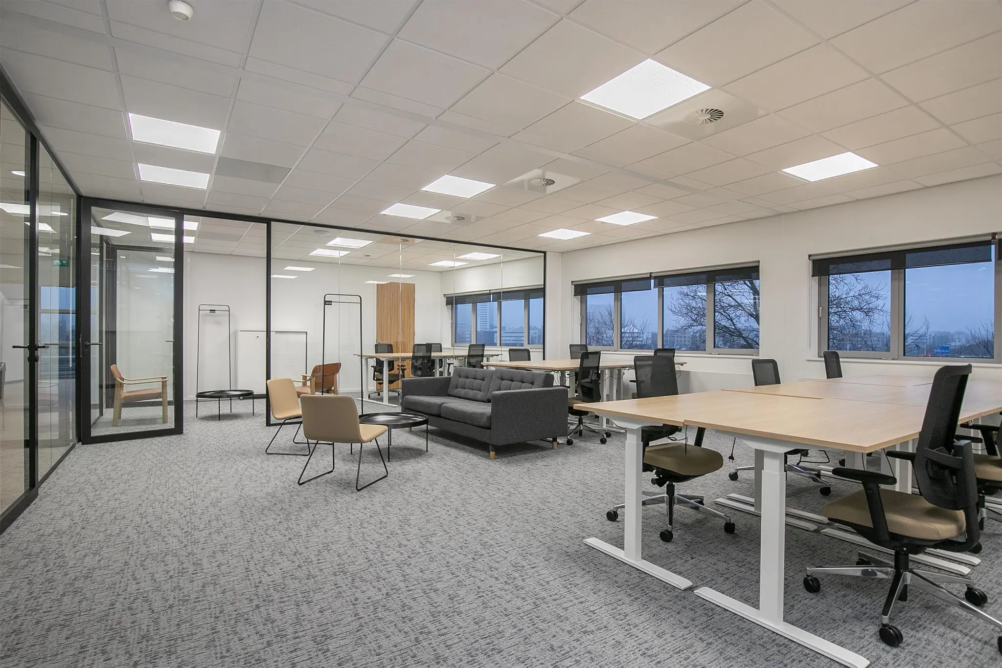 Moderne open kantoorruimte in Rivium Quadrant met bureaus, stoelen en een loungegedeelte.